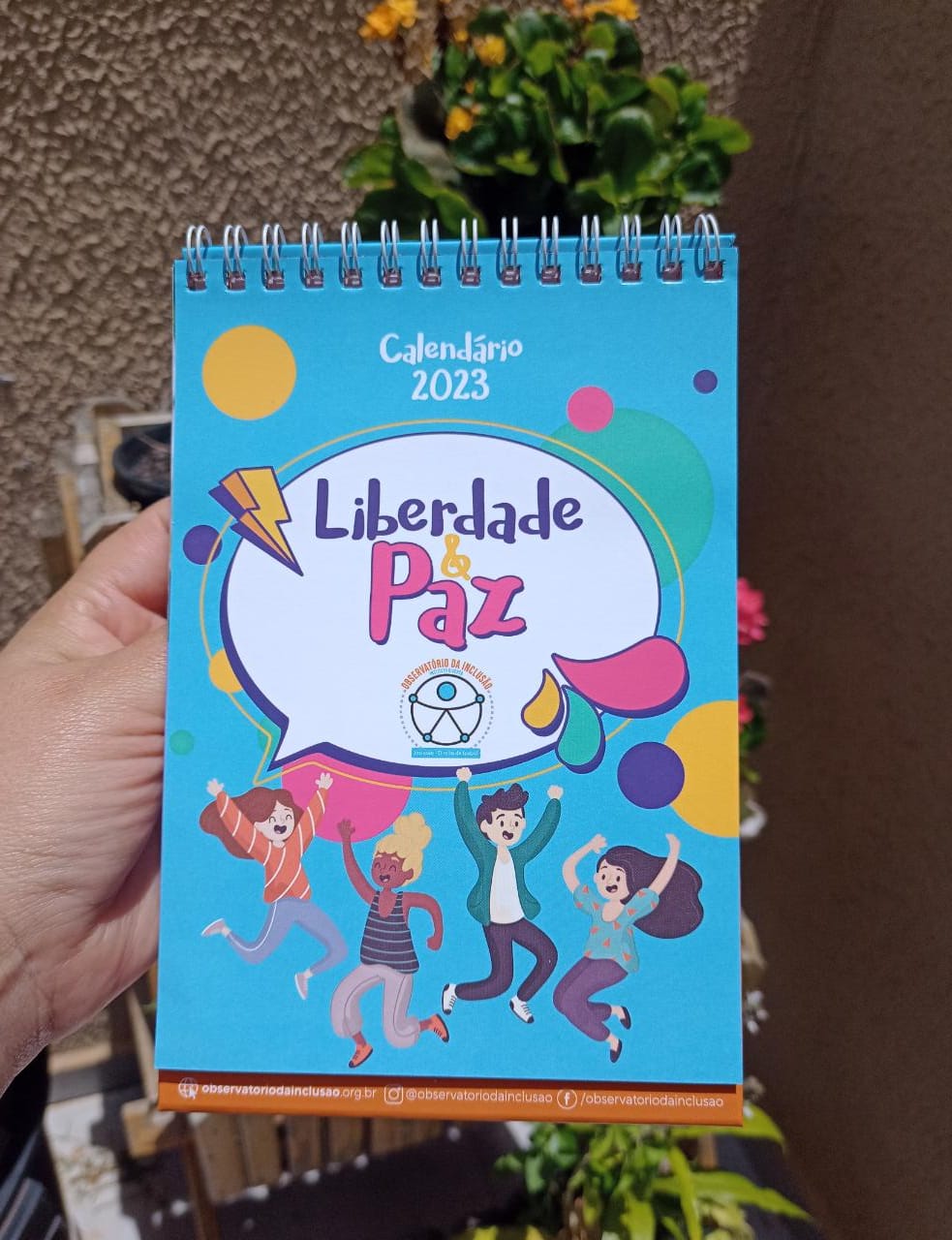 Descrição: A imagem contém calendário com a ilustração de várias crianças e a frase “Liberdade e paz”.